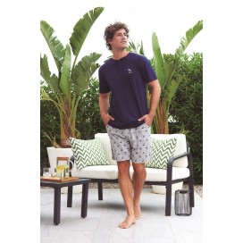 Hombre con pijama de algodón: camiseta azul marino con cuello henley y pantalón corto gris con micro estampado de palmeras.