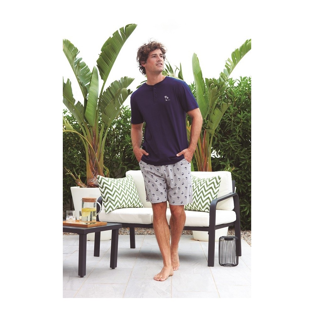 Hombre con pijama de algodón: camiseta azul marino con cuello henley y pantalón corto gris con micro estampado de palmeras.