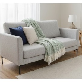 Manta multiusos de algodón cuadros verde 120x190 cm. extendida sobre un sofa