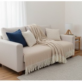 Manta multiusos algodón rayas beige 120x190 cm. extendida sobre un sofa