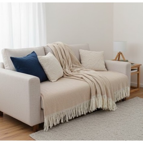 Manta multiusos algodón rayas beige 120x190 cm. extendida sobre un sofa
