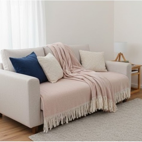 Manta multiusos algodón rayas rosa 120x190 cm. sobe un sofa en conjunto con cojines