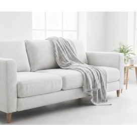 Manta multiusos algodón espiga gris perla sobre un sofa