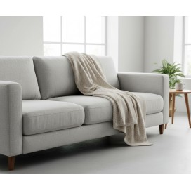 Manta multiusos algodón espiga beige sobe un sofa
