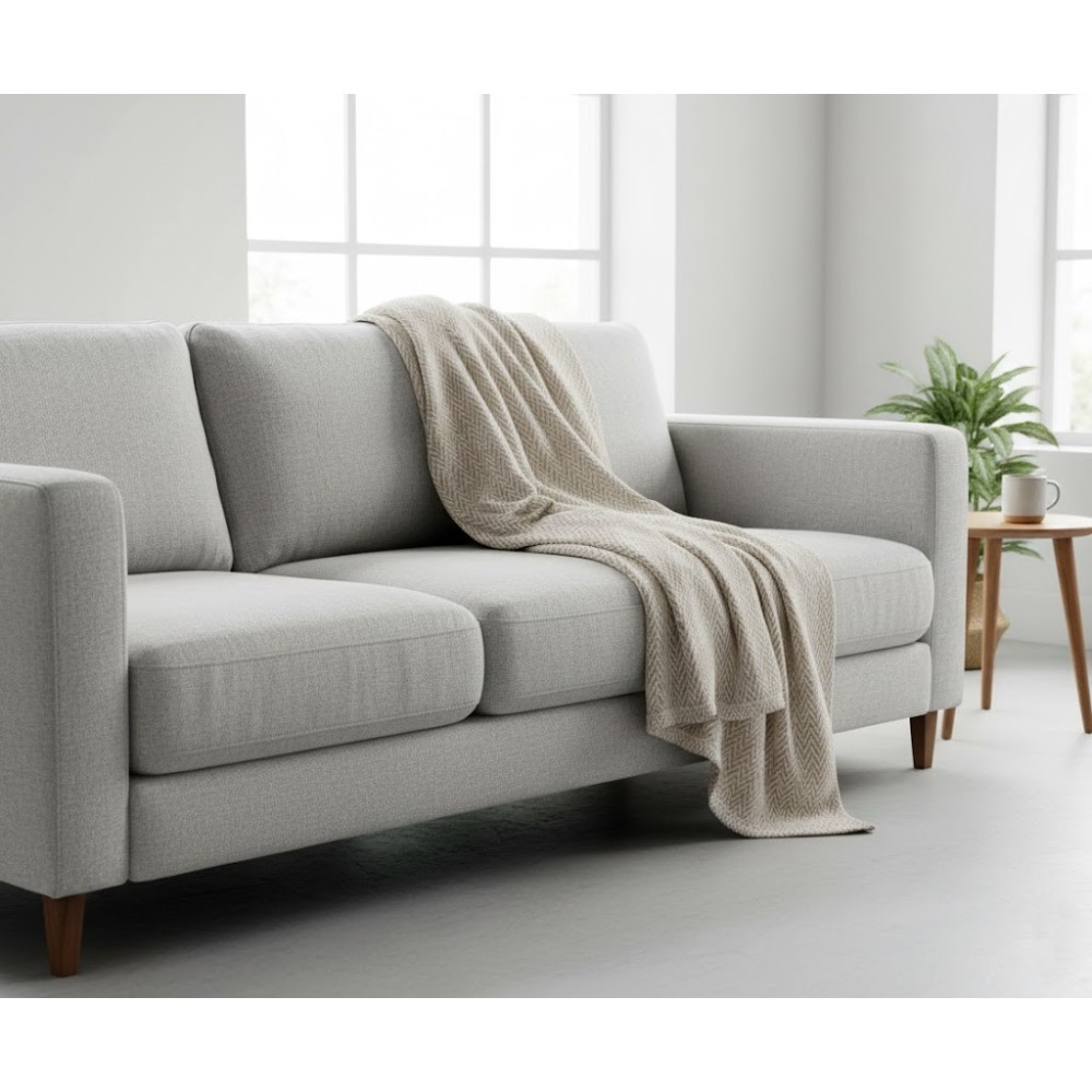 Manta multiusos algodón espiga beige sobe un sofa