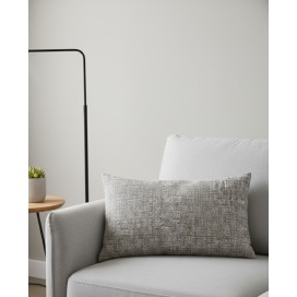 Funda de cojín rectangular de 40x60 cm con textura jaspeada en tonos beige, composición de algodón y poliéster sobre un sofa