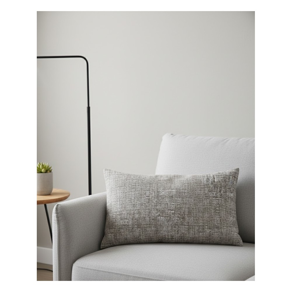Funda de cojín rectangular de 40x60 cm con textura jaspeada en tonos beige, composición de algodón y poliéster sobre un sofa