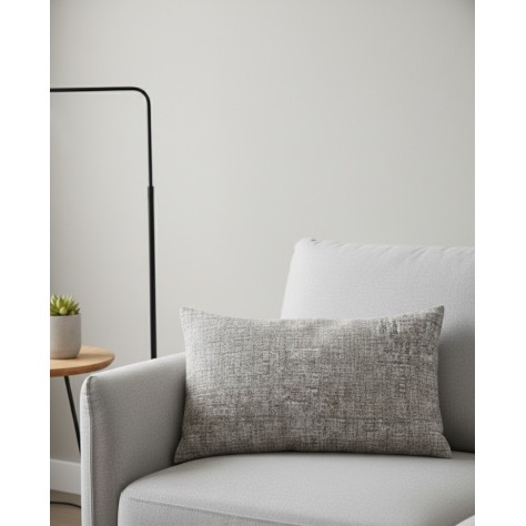 Funda de cojín rectangular de 40x60 cm con textura jaspeada en tonos beige, composición de algodón y poliéster sobre un sofa