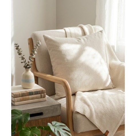 cojin beige sobre un sillon