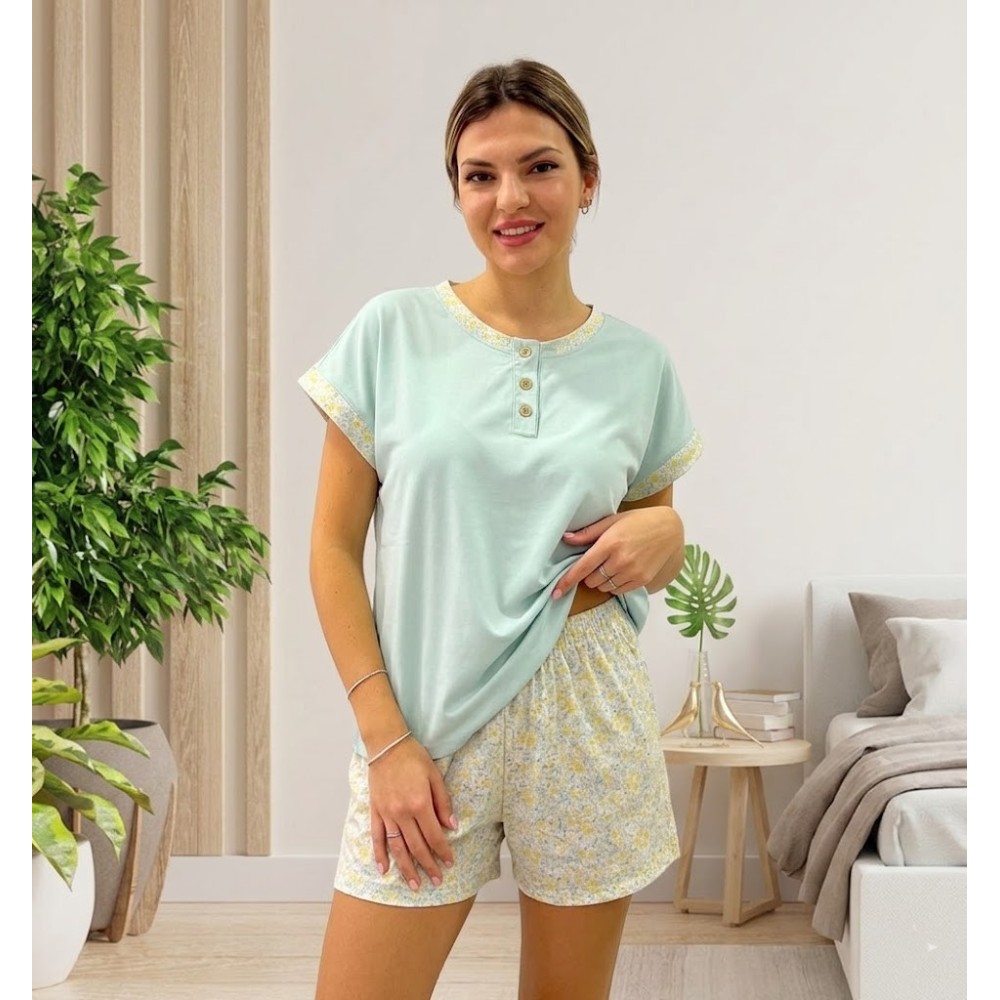 Fotografía de una mujer sonriente posando en un dormitorio con un pijama de verano de dos piezas en 100% algodon