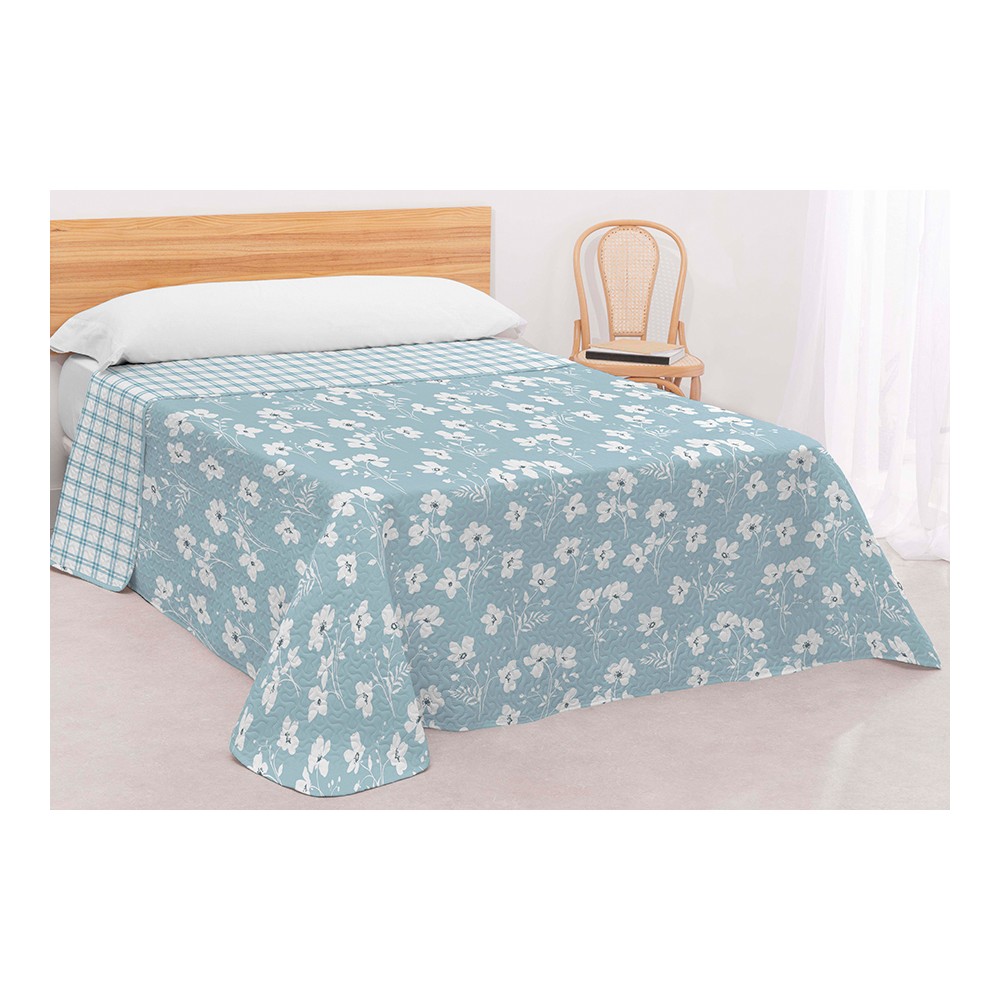 Colcha bouti reversible en color azul con estampado de flores blancas y reverso de cuadros, confeccionada en microfibra